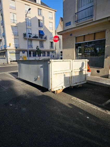 Deux bennes de location stationnées dans une rue de centre-ville pendant un chantier